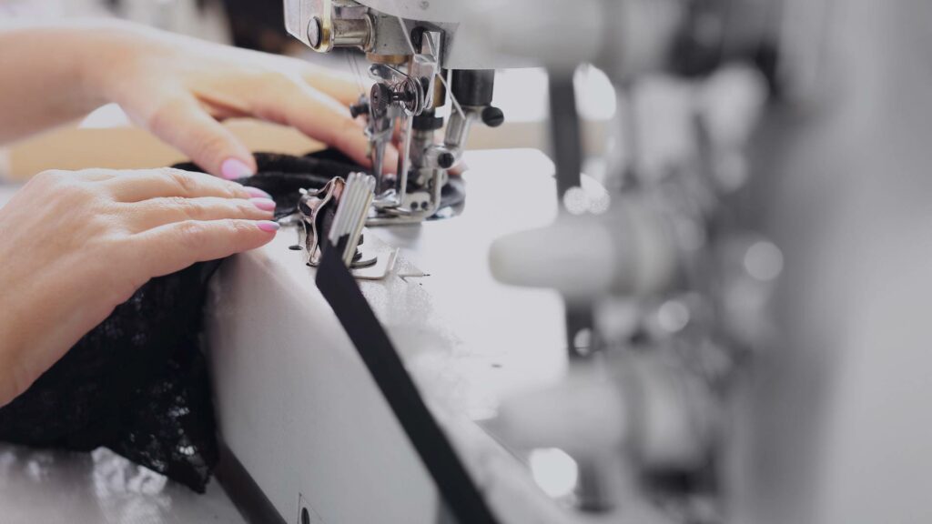 Une artisane coud ses créations sur une machine à coudre