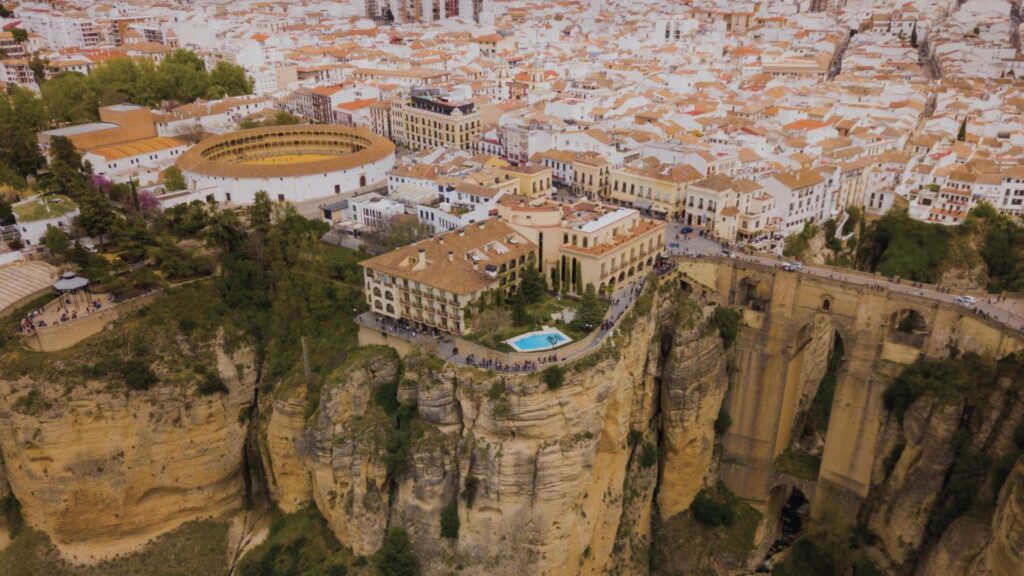 Vue du Puente Nuevo de Ronda traversant le canyon du Tajo, avec les maisons blanches accrochées aux falaises et un ciel bleu intense de juillet.