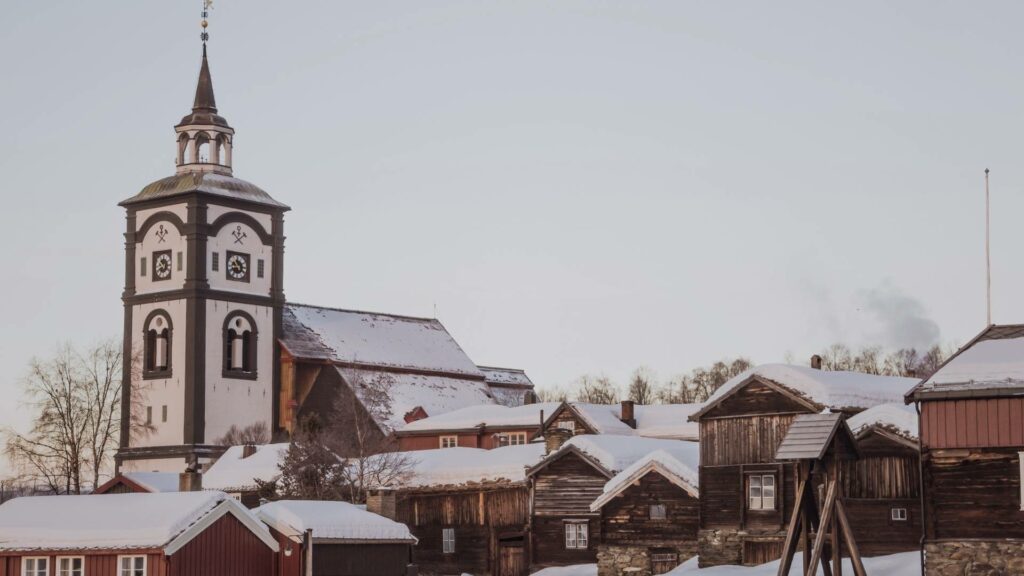 Église de Røros et maisons en bois recouvertes de neige, au cœur de la vieille ville classée au patrimoine mondial de l’UNESCO