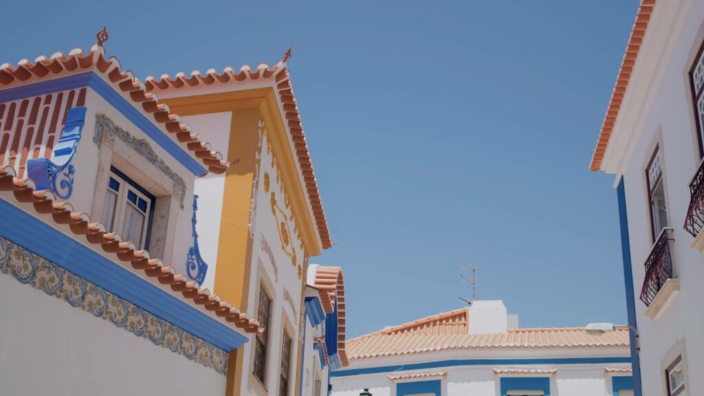 Vue sur les maisons blanches et colorées d’Ericeira sous le soleil de mai.