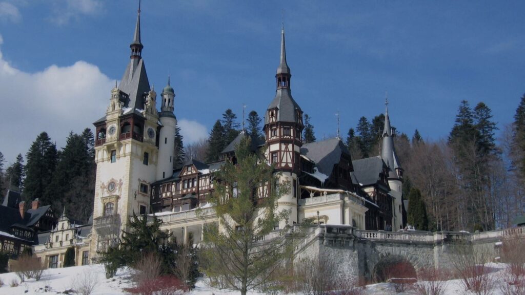 Château de Peleș sous la neige à Sinaia, Roumanie, entouré de pins givrés et perché au cœur des Carpates