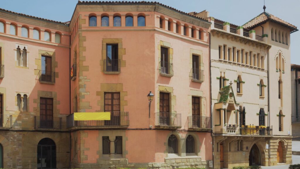 Vic, Espagne : Place médiévale ensoleillée avec bâtiments colorés.
